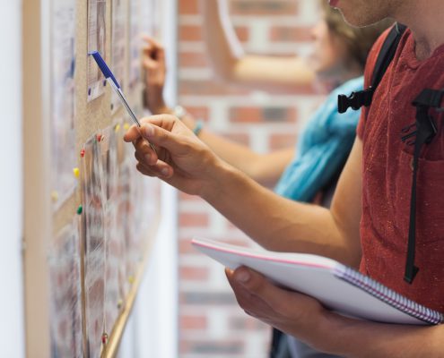 students checking the bulletin board at school