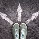 feet on pavement with three arrows showing three different paths to take