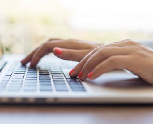 hands typing on a laptop