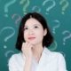 student thinking with question marks on chalk board behind her