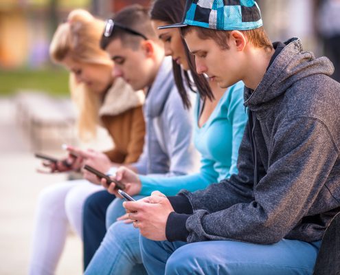 high school students looking at their phones