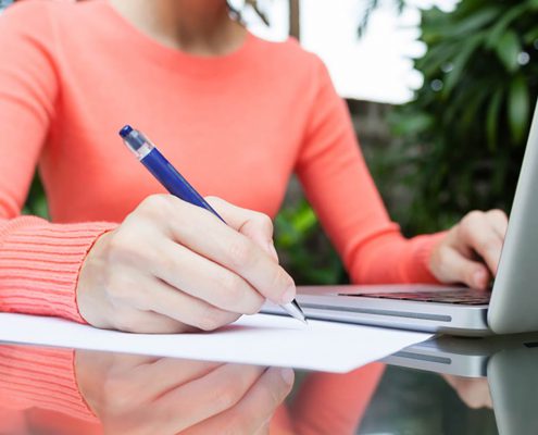 young woman with a laptop and pen