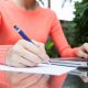 young woman with a laptop and pen